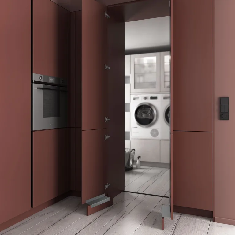 Façade terracotta ouverte sur une buanderie dissimulée avec lave-linge et sèche-linge